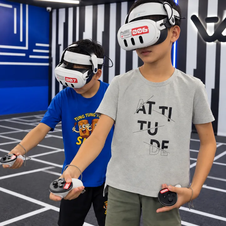 Two children in grey and blue T-shirts wear VR headsets and hold controllers at Another World Da Nang.